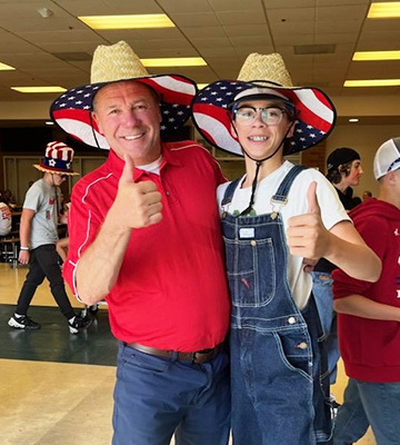 Student and adult wearing patriotic hats
